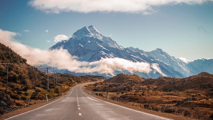 Image, road driving through the foothills facing a snowy mountain